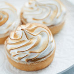 Cremose crostatine alla zucca meringate servite su un piatto bianco