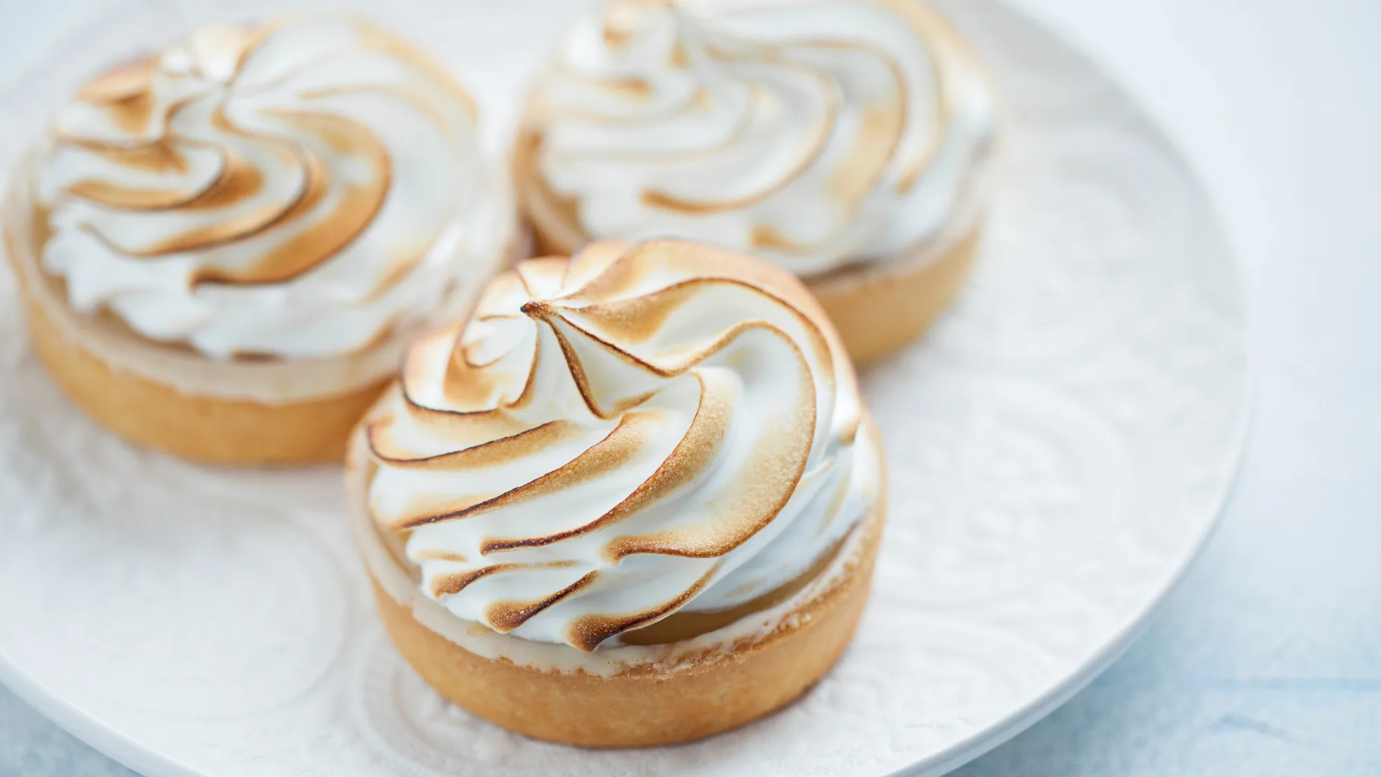 cremose crostatine alla zucca meringate servite su un piatto bianco