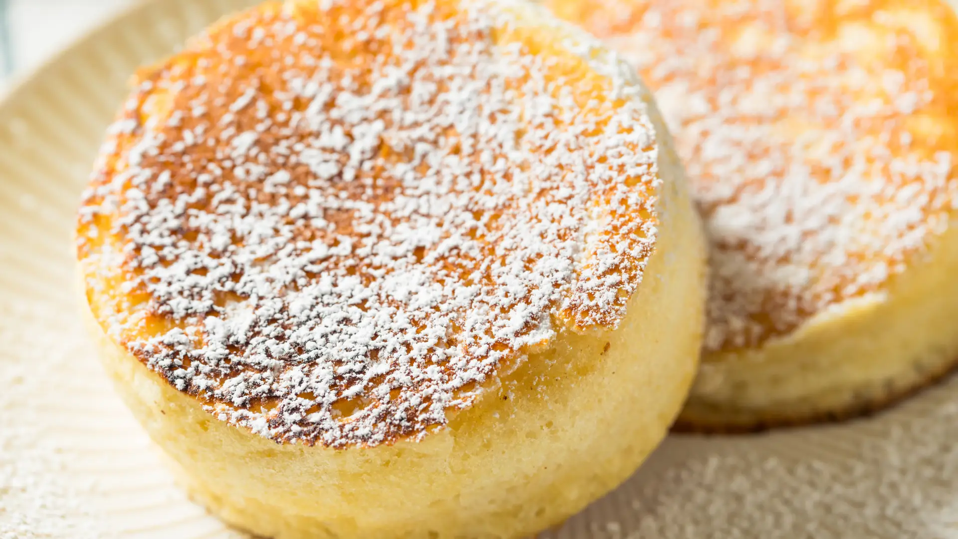 Tall and fluffy Japanese soufflé pancakes, golden brown and dusted with powdered sugar